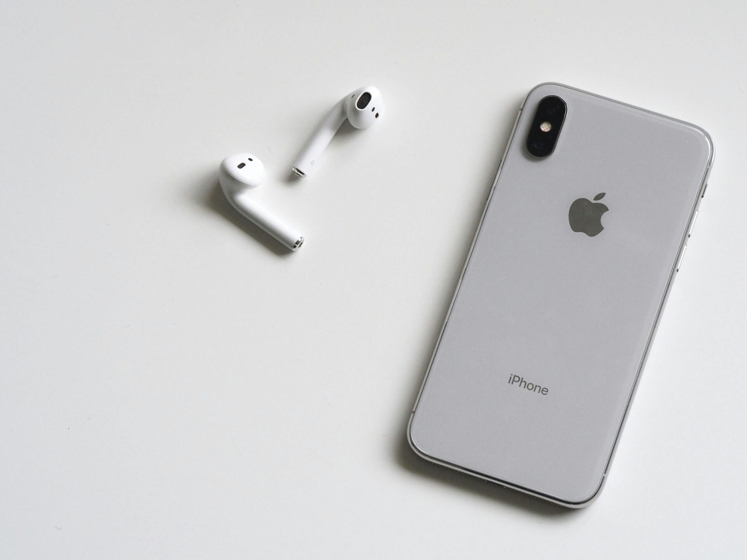 En iPhone med hörlurar som ligger löst på bordet